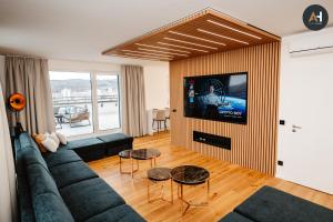 uma sala de estar com um sofá e uma televisão de ecrã plano em Albelli Luxury Skyview em Košice