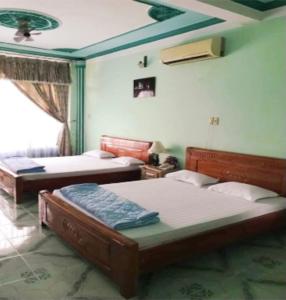 - une chambre avec deux lits et un plafond dans l'établissement Khách Sạn Xuân Quang, à Cần Thơ