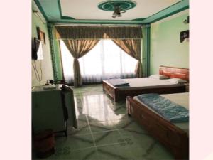 una camera con due letti e una finestra di Khách Sạn Xuân Quang a Can Tho