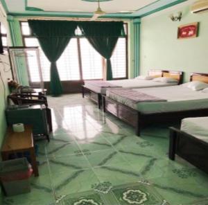 a bedroom with two beds in a room with green floors at Khách Sạn Xuân Quang in Can Tho