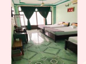 una camera con due letti in una stanza con pavimenti verdi di Khách Sạn Xuân Quang a Can Tho