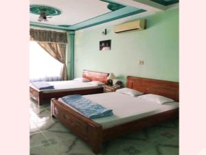 - une chambre avec 2 lits et une fenêtre dans l'établissement Khách Sạn Xuân Quang, à Cần Thơ