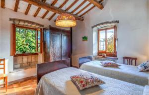 1 dormitorio con 2 camas y lámpara de araña en 4 Bedroom Beautiful Home In Acqualagna en Acqualagna