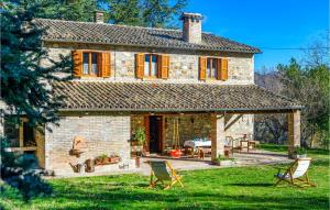 una casa de piedra con 2 sillas en el patio en 4 Bedroom Beautiful Home In Acqualagna en Acqualagna