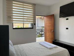 a bedroom with a bed and a window with a television at Riviera Vichayito in Vichayito