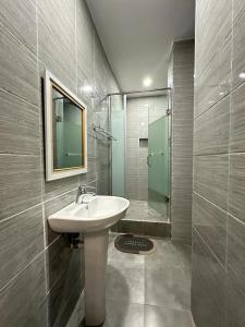 a bathroom with a sink and a glass shower at Asher’s Villa in Garki