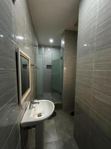 uma casa de banho com um lavatório e um chuveiro em Asher’s Villa em Garki