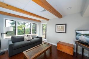 un soggiorno con un divano e un tavolo di Secluded Waterfront A-Frame Cabin w/ Pvt Lake a Fithian