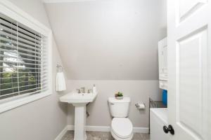 un bagno bianco con un water e un lavandino di Secluded Waterfront A-Frame Cabin w/ Pvt Lake a Fithian Altre 28 foto