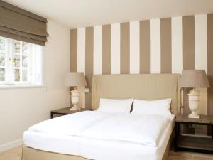 a bedroom with a large white bed with striped walls at Inselhaus in Kampen