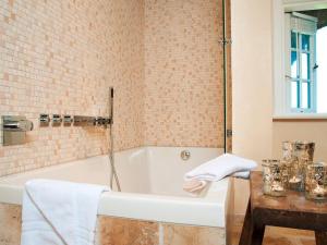 a white bath tub in a bathroom with a table at Inselhaus in Kampen