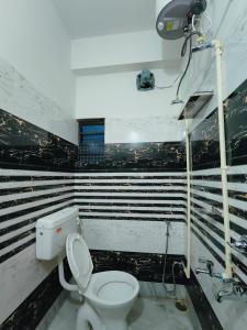 a bathroom with a toilet and a camera on the wall at GULAB LODGE in Siliguri