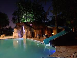 a slide in a swimming pool at night at Clyde's on Dale Guest House in Springs