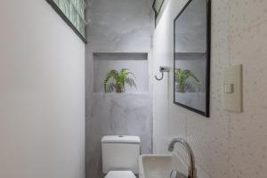 uma casa de banho com um WC branco e um lavatório. em Easy Star - Apto 2 quartos bem iluminado perto da Avenida Paulista - FL01H em São Paulo