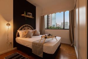 um quarto com uma cama com uma mesa em Easy Star - Apto 2 quartos bem iluminado perto da Avenida Paulista - FL01H em São Paulo