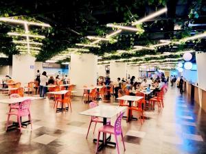 a group of people sitting at tables in a cafeteria at Kuching Kozi Square Homestay Apartment in Kuching
