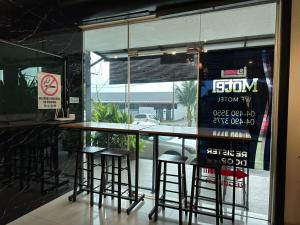 un bar con taburetes frente a una ventana en WF Motel, en Kulim