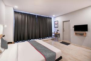 a bedroom with a bed and a flat screen tv at Townhouse De Alphabet Karmanghat in Hyderabad