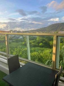 una mesa y sillas en un balcón con vistas en The Regent Kamala Penthouse with private pool en Kamala Beach