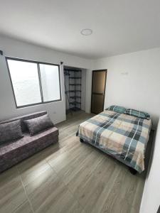 ein Schlafzimmer mit einem Bett und einem Sofa darin in der Unterkunft Casa Halley #6 con vista al mar in Playas