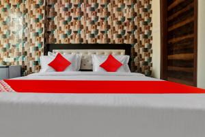 a bedroom with a large bed with red pillows at OYO Flagship Hotel Metro Height's near Nangloi Railway metro station in New Delhi
