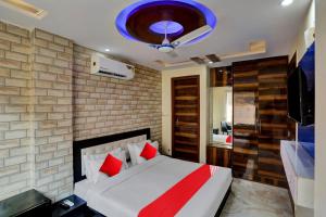 a bedroom with a large bed with red pillows at Super OYO Flagship Hotel Metro Height's near Nangloi Railway metro station in New Delhi