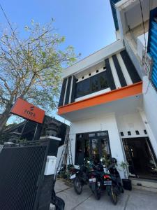 two motorcycles parked in front of a building at Fora Capsule Hostel Tuban Kuta Bali in Kuta