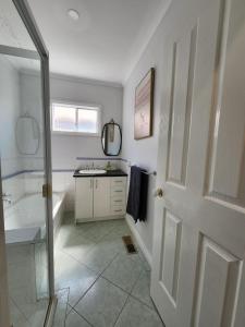 a bathroom with a sink and a shower and a door at Rye Getaway on Loatta in Rye