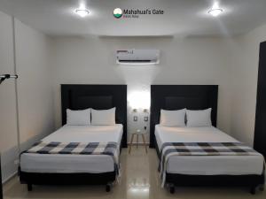 2 camas en una habitación con paredes blancas en Mahahual's Gate (Kalan Naay), en Mahahual