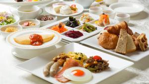 une table avec plusieurs assiettes de nourriture dans l'établissement Hotel Monterey Osaka, à Osaka