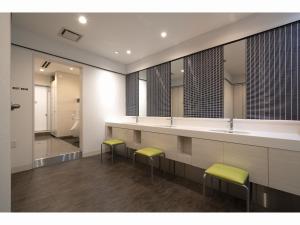 a bathroom with two sinks and two stools at Capsule Hotel J Garden Shin-Osaka in Osaka