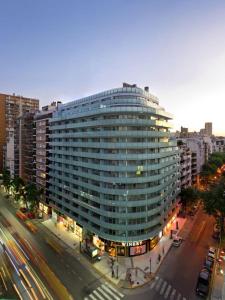 un gran edificio de cristal en una calle de la ciudad con tráfico en Amplio y Hermoso con Hidromasaje en Buenos Aires