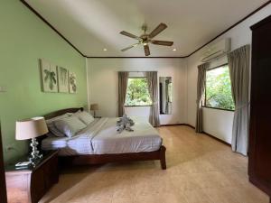 Schlafzimmer mit einem Bett und einem Deckenventilator in der Unterkunft Woodlawn Villas Resort in Ko Tao