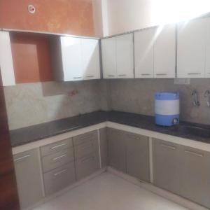 a kitchen with white cabinets and a counter top at Anant home stay in Ujjain