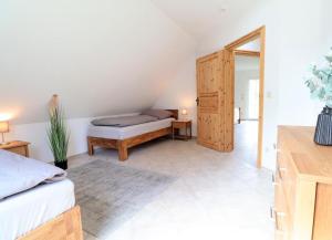 een slaapkamer met een bed en een houten deur bij Flechtdorfer Waldblick - 130 qm großes Ferienhaus und großem Grundstück und Bachlauf und Terrasse für 6 Gäste in Diemelsee