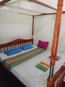 1 cama en una tienda de campaña con almohadas coloridas en Viraj's Garden, en Tangalle
