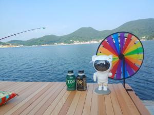 zwei Flaschen Bier und eine Figur auf dem Steg in der Unterkunft Tagoja Caravanboat Stay in Tongyeong