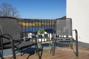 2 sillas y una mesa en el balcón en diemelblick acht - Ferienhaus für 6 Personen mit Sauna, Garten und Dachterrasse mit Panoramablick, en Heringhausen
