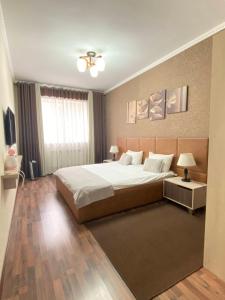 Un dormitorio con una cama grande y una ventana en Caravan Hotel, en Karakol