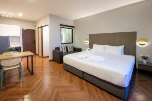 una habitación de hotel con una cama grande y una mesa en Nature Vista Rawai en Nai Harn Beach