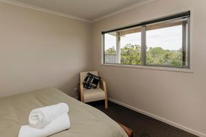 een slaapkamer met een bed, een raam en een stoel bij Dorset Retreat in Hillsborough