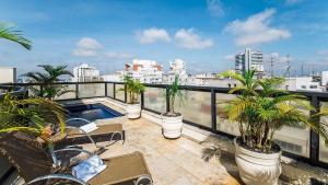 a balcony with palm trees and a swimming pool on a building at Easy Star - Flat Aconchegante C/Vaga na Bela Cintra - XA03G in Sao Paulo