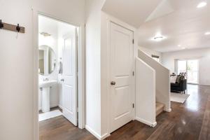 un couloir blanc avec une porte blanche et une salle de bains. dans l'établissement Central 3BR/2.5BA Home Near PDX Airport, à Vancouver