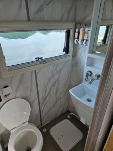 a small bathroom with a toilet and a sink at Tagoja Caravanboat Stay in Tongyeong