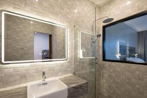 a bathroom with a sink and a glass shower at Nature Vista Rawai in Nai Harn Beach