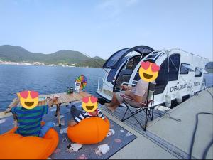 a group of people sitting at a table on a boat at Tagoja Caravanboat Stay in Tongyeong