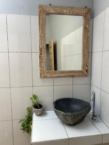 een badkamer met een stenen wastafel en een spiegel bij blue waves hostel amed in Ambat