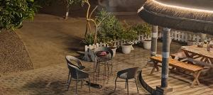 patio z krzesłami, stołem i roślinami w obiekcie Shobhayan inn w mieście Ayodhya