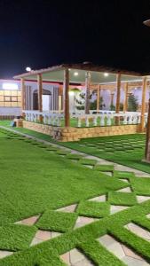 dom z zielonym trawnikiem ze słowem x w obiekcie أستراحة السعادة w mieście Jalan Bani Buhassan