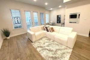ein Wohnzimmer mit einem weißen Sofa und einem TV in der Unterkunft Townhouse in Houston in Houston